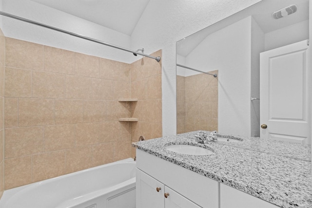 bathroom with vanity and tiled shower / bath