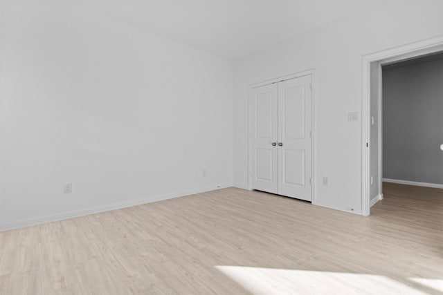 unfurnished bedroom with light hardwood / wood-style floors and a closet