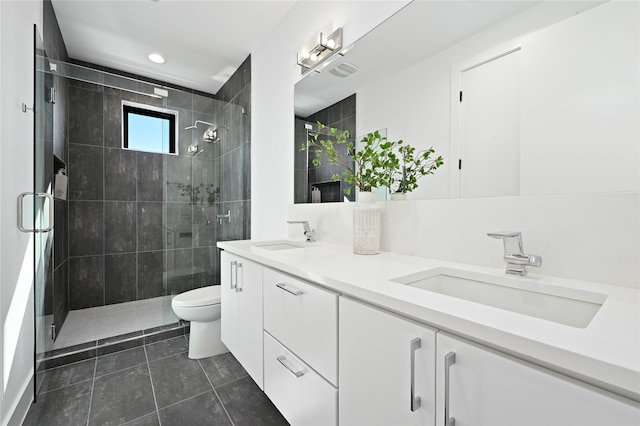 bathroom with tile patterned floors, vanity, toilet, and an enclosed shower