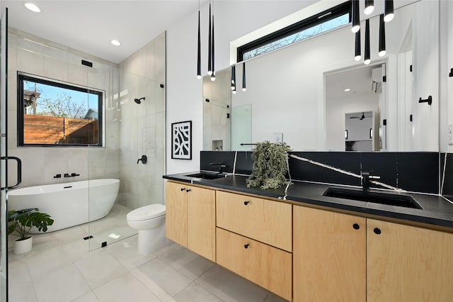 full bathroom featuring tile patterned flooring, vanity, a healthy amount of sunlight, and tile walls