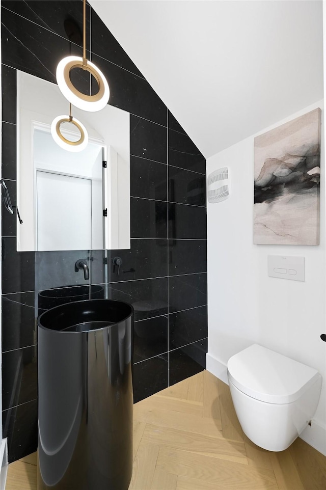 bathroom with vanity, toilet, and tile walls