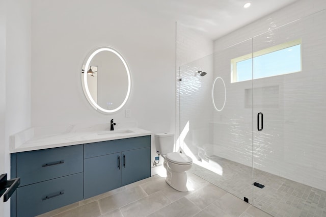 bathroom featuring tile patterned floors, vanity, a shower with shower door, and toilet