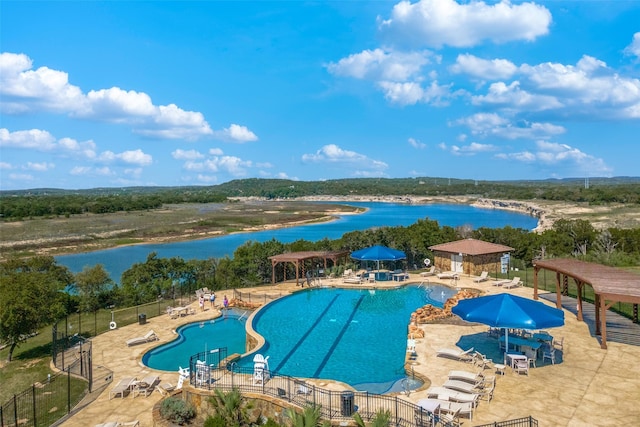 view of pool with a patio, a water view, and a water slide