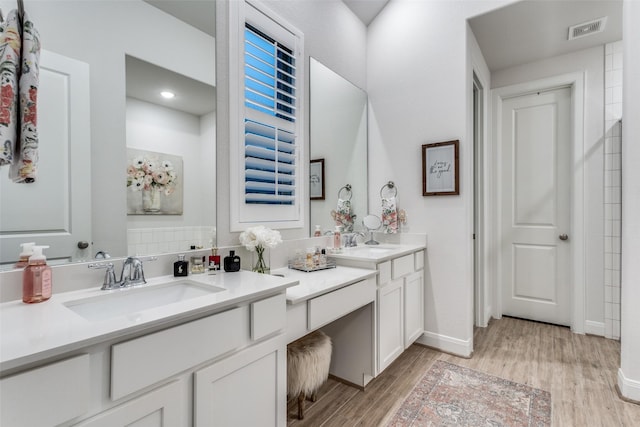 bathroom with decorative backsplash, vanity, and hardwood / wood-style flooring