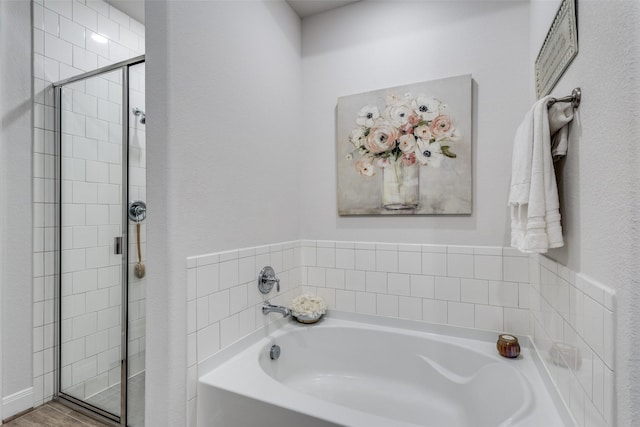 bathroom featuring shower with separate bathtub