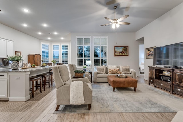 living room with light hardwood / wood-style flooring and ceiling fan