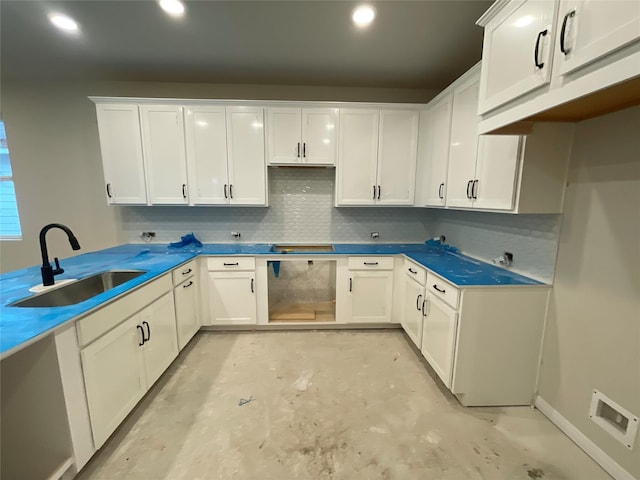 kitchen featuring decorative backsplash, white cabinets, and sink