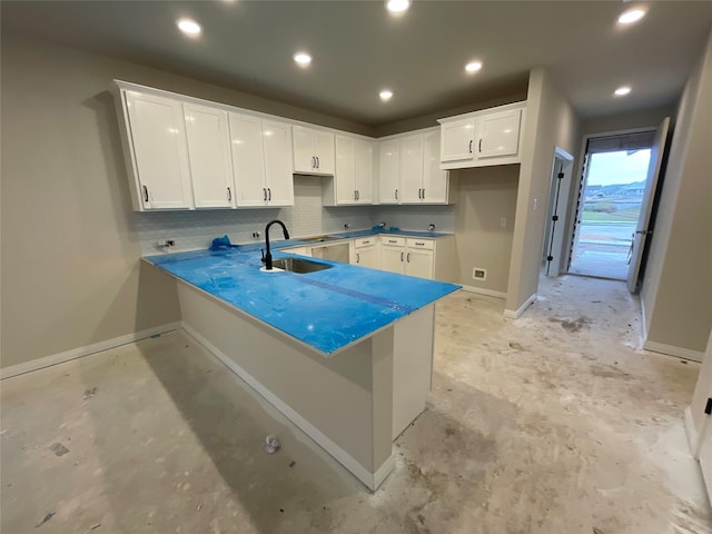 kitchen with sink, white cabinets, and kitchen peninsula