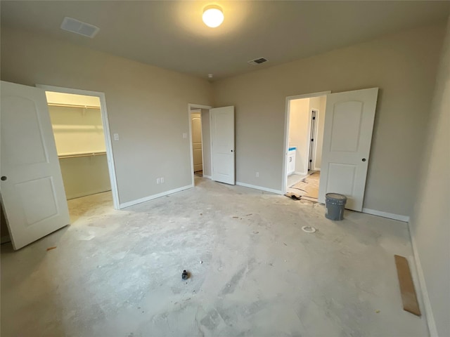 unfurnished bedroom with a closet and a spacious closet