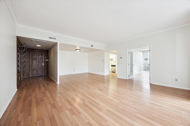 empty room featuring crown molding and light wood-type flooring