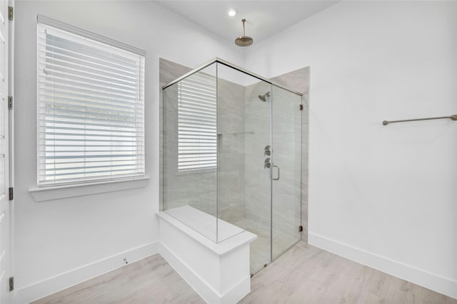 bathroom with a shower with shower door and hardwood / wood-style flooring