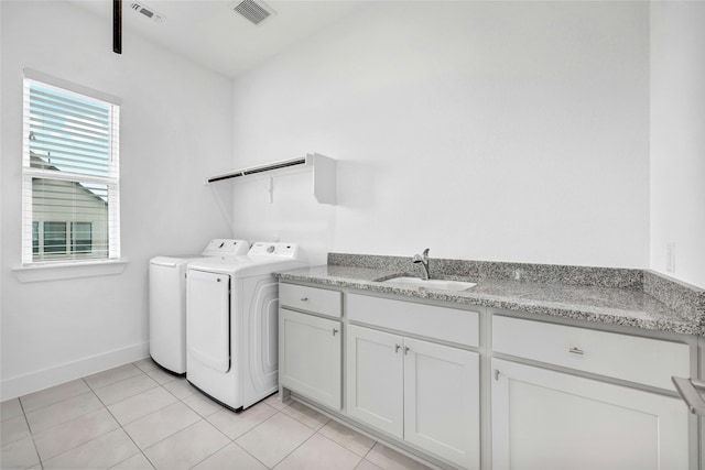 clothes washing area featuring sink, light tile patterned floors, and washer and dryer