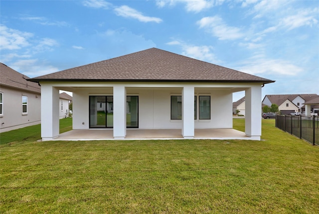 back of house with a patio and a lawn