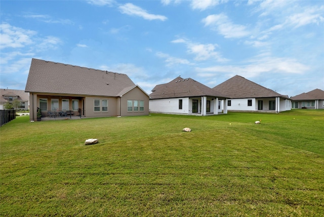 rear view of property featuring a lawn