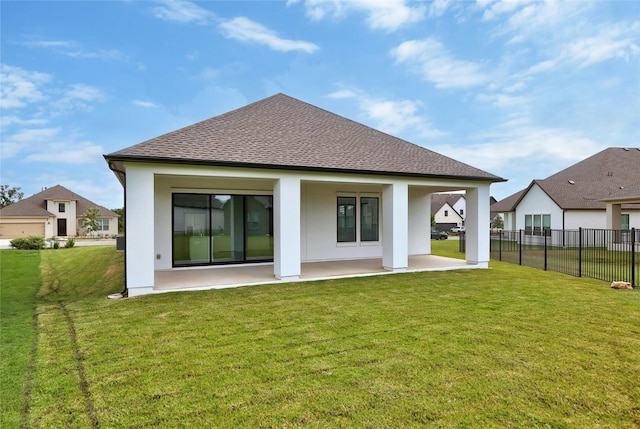 rear view of house with a lawn and a patio