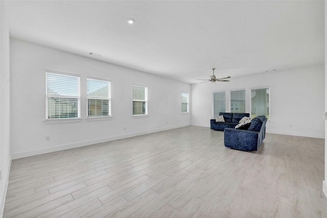 living room featuring ceiling fan, light hardwood / wood-style floors, and a healthy amount of sunlight