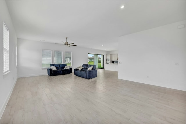 living room with ceiling fan and light hardwood / wood-style flooring