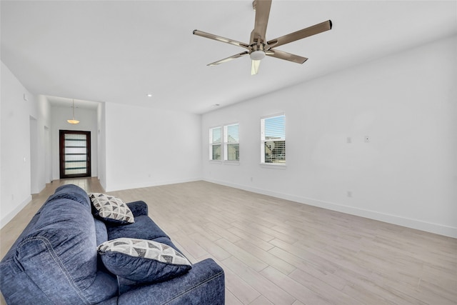 living room with ceiling fan and light hardwood / wood-style flooring