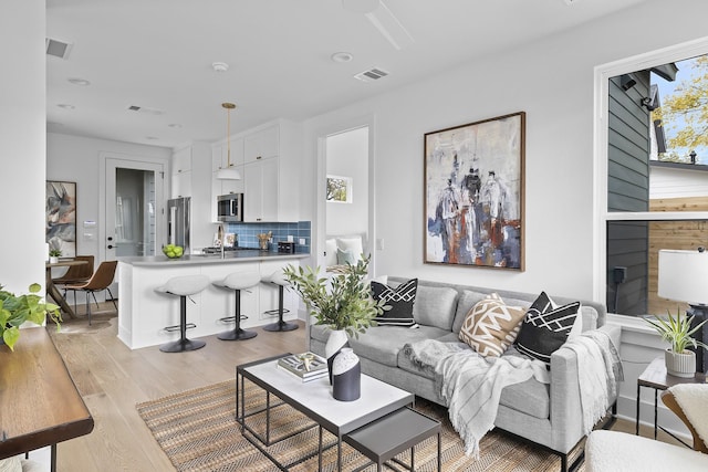 living room with light wood-type flooring and a fireplace