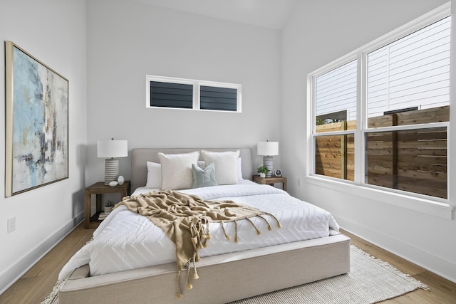 bedroom featuring lofted ceiling and hardwood / wood-style floors