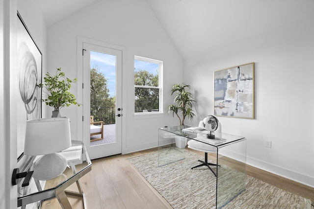 office with high vaulted ceiling and light wood-type flooring