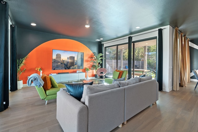 living room with a textured ceiling and light hardwood / wood-style flooring