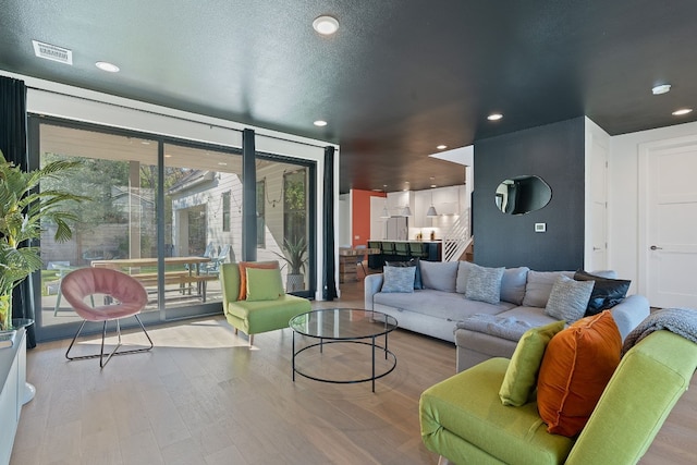 1604 Miriam Ave, Austin, TX 78702 - living area with recessed lighting, wood finished floors, and a wall of windows