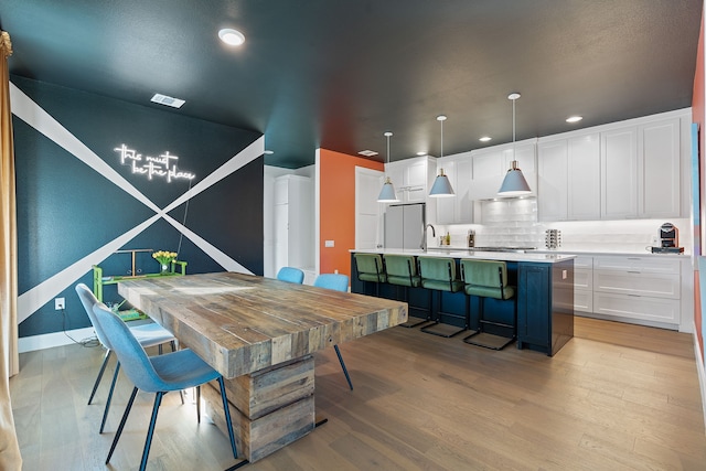 dining area with sink and light hardwood / wood-style flooring