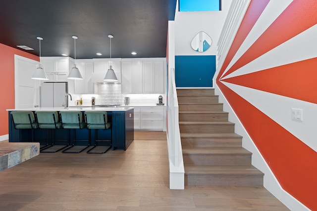 stairway featuring sink and hardwood / wood-style flooring