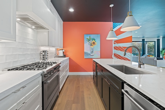 kitchen with pendant lighting, white cabinets, tasteful backsplash, custom range hood, and stainless steel appliances