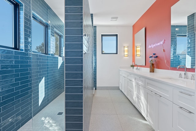 bathroom featuring a wealth of natural light, vanity, and walk in shower