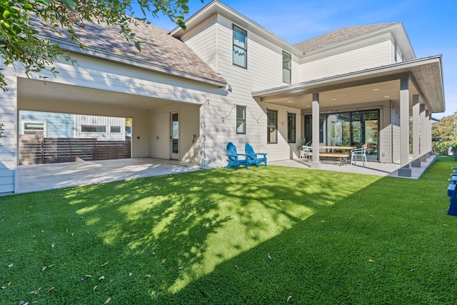 back of property with a patio area and a yard