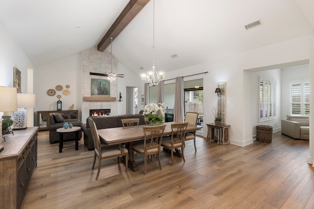 dining space featuring a fireplace, a healthy amount of sunlight, beam ceiling, and wood-type flooring