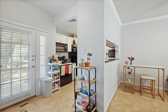 kitchen with visible vents, a textured ceiling, range with electric stovetop, white cabinetry, and black microwave