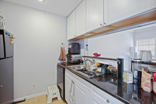 715 22 1/2 St Unit 101, Austin, TX 78705 - kitchen with freestanding refrigerator, white cabinets, light tile patterned floors, and black dishwasher