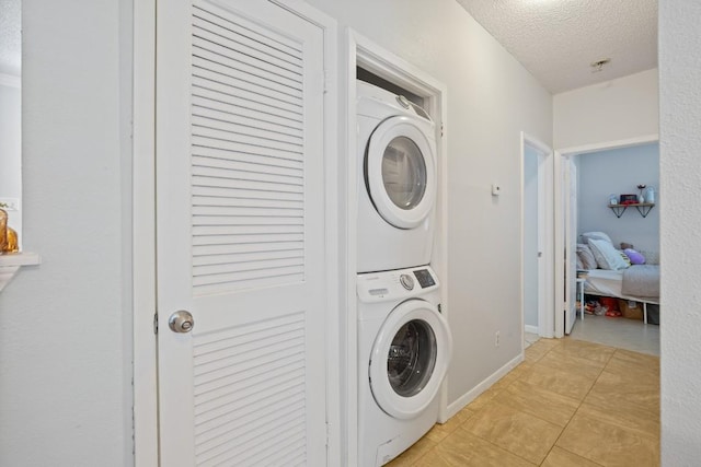 715 22 1/2 St Unit 101, Austin, TX 78705 - laundry room with estacked washer and dryer, a textured ceiling, and light tile patterned floors