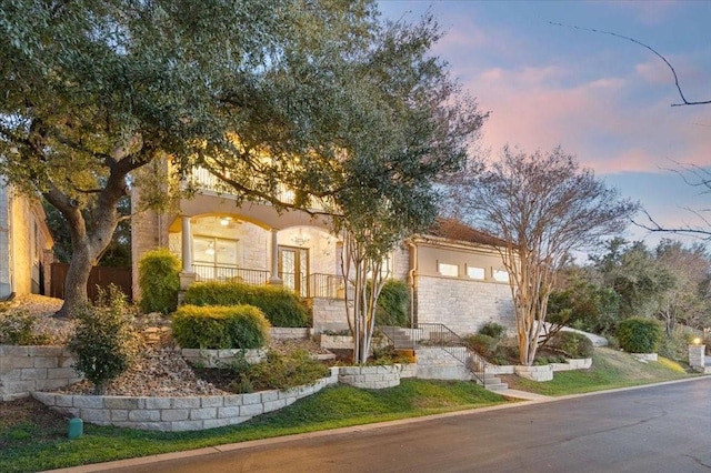 view of front of home featuring stone siding and stucco siding