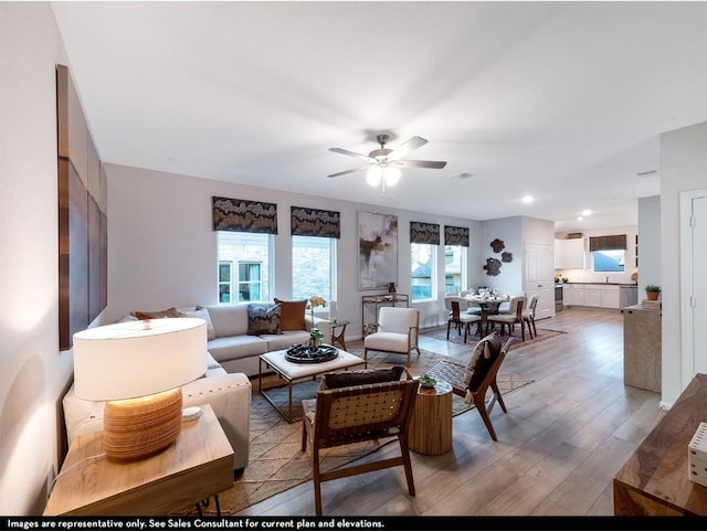 living area with visible vents, ceiling fan, recessed lighting, and light wood finished floors