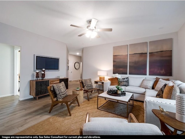 living room with ceiling fan, light wood-style flooring, and baseboards