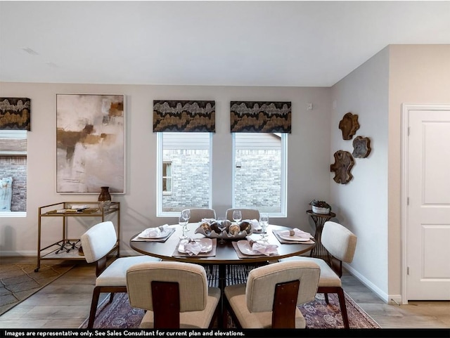 dining space featuring baseboards and light wood-style flooring