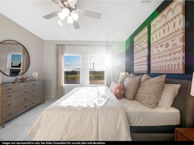 carpeted bedroom featuring lofted ceiling, ceiling fan, and visible vents