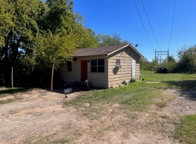 view of front of home with an outbuilding and a front lawn