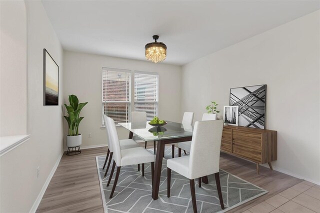 dining area with a notable chandelier and light hardwood / wood-style floors