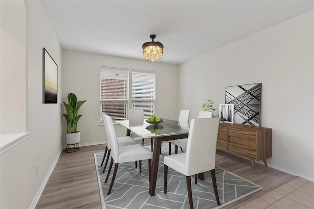 dining area featuring baseboards, a chandelier, and light wood-style floors