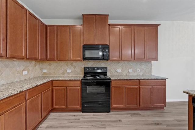 kitchen with backsplash, black appliances, light wood-style floors, light stone countertops, and brown cabinetry