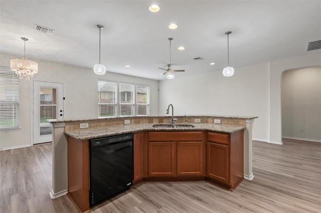 kitchen featuring sink, ceiling fan, black dishwasher, an island with sink, and light hardwood / wood-style floors