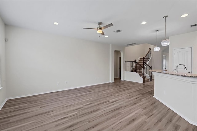 unfurnished living room featuring ceiling fan and light hardwood / wood-style flooring