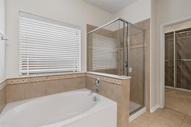 bathroom featuring tile patterned flooring and shower with separate bathtub