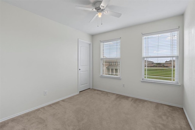 carpeted spare room featuring ceiling fan