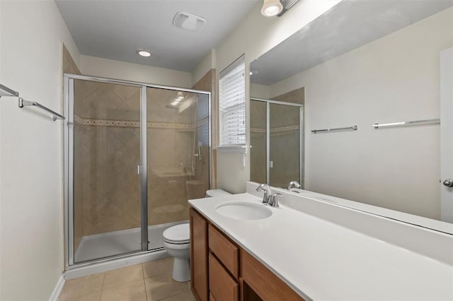 bathroom featuring tile patterned flooring, vanity, toilet, and a shower with door